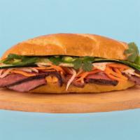Steak Banh Mi · Grilled sliced steak with cucumber, jalapeno, cilantro, pickled carrots and sriracha mayo on...