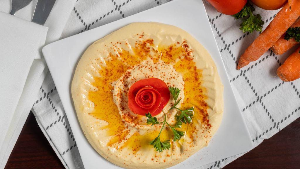 Hummus · A Mixture of garbanzo beans with a touch of garlic, lemon juice,
and tahini sauce, topped with olive oil and served with pita bread.