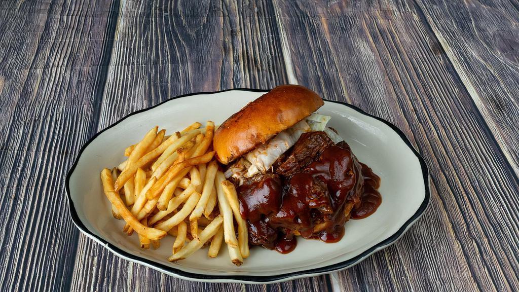 Old Western Bbq Beef Sandwich · A generous portion of show roasted beef brisket on a burger bun topped with melted cheddar cheese, tomato slices, white cabbage, red onions and a generous portion of our BBQ sauce.