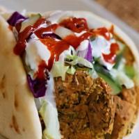 Falafel Wrap · Patty made from ground chickpeas, wrapped in a warm pita topped with lettuce, onion, cabbage...