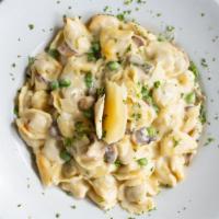 Tortellini Di Pollo · Chicken filled pasta with alfredo sauce, mushroom and green peas.