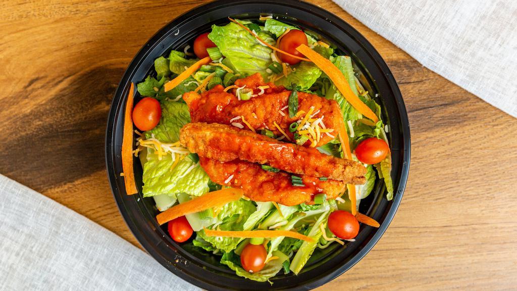 Spicy Buffalo Chicken Tender Salad · Crispy chicken tenders tossed in a spicy buffalo sauce, mixed cheese, tomato, served over iceberg lettuce, topped with diced green onions, served with ranch dressing.