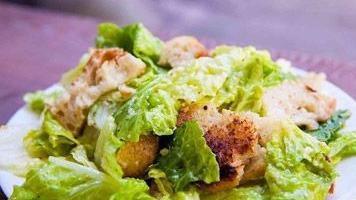 Crispy Chicken Caesar Salad · Crispy chicken tenders, Parmesan cheese and croutons, served over romaine lettuce, served with Caesar dressing.