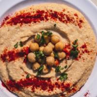 Hummus · Pureed chickpeas mixed with tahini, garlic, lemon juice and olive oil. Served with pita bread.
