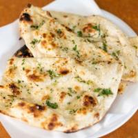 Garlic Naan · Indian bread with garlic and cilantro prepared in tandoori.