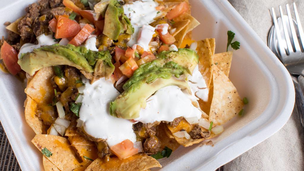 Nachos · Deep fried corn tortilla chips covered with protein and toppings