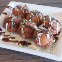 Takoyaki · Ball-shaped Japanese-style octopus snacks topped with seaweed powder, bonito flakes, and tak...