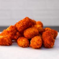 Spiced Potato Tots · Crispy potato tots tossed in a medium heat spiced Nashville seasoning blend. Served with a s...
