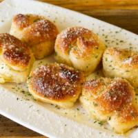 Garlic Knots · Baked knotted pizza dough rolls soaked in fresh garlic and olive oil.