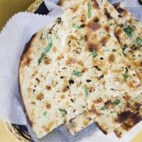 Garlic Naan · Traditional unleavened white flour bread freshly cooked in tandoori clay oven topped with ga...