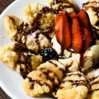 Banana Fritters A La Mode · Fresh bananas lightly battered and fried and served with vanilla ice cream topped with choco...