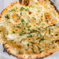Garlic Naan · Garlic and herb-infused, teardrop-shaped, leavened bread baked in a tandoor oven