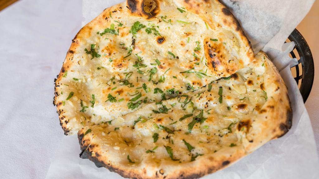 Garlic Naan · Garlic and herb-infused, teardrop-shaped, leavened bread baked in a tandoor oven
