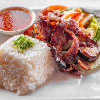 Pork Chop On Rice · Deep-fried pork chop, green onion sauce, kimchi Khmer style, cucumber, tomato, and house spe...