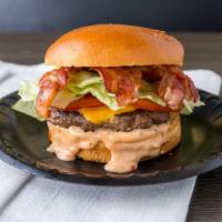 Bacon, Avocado Cheeseburger · A 1/3 lb Burger topped with bacon and American cheese on a brioche bun with lettuce, tomato ...