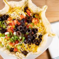 Taco Salad · A crispy tortilla bowl filled with shredded lettuce, ground beef or shredded chicken, mixed ...
