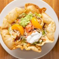 Super Tostada · Flour tortilla bowl with choice of meat. Served with beans, lettuce, tomatoes, guacamole, so...