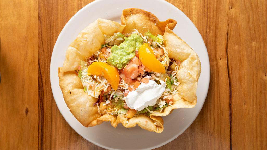 Super Tostada · Choice of meat, served with beans, lettuce, tomatoes, guacamole, sour cream, and salsa.