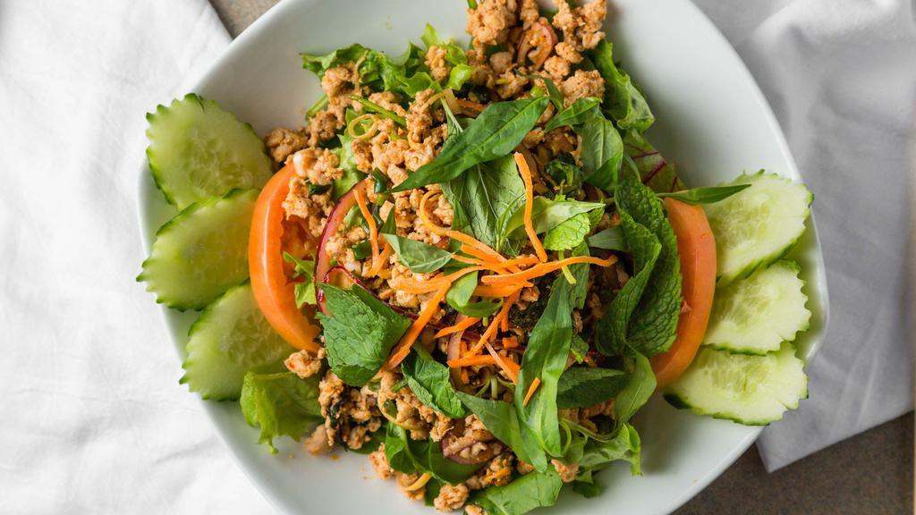 Larb (Chicken) · Gluten-free. Spicy minced chicken salad seasoned with lemongrass, roasted chili powder, roasted rice powder, red, and green onions, mint leaves, cilantro and lime juice, served over a bed of lettuce.