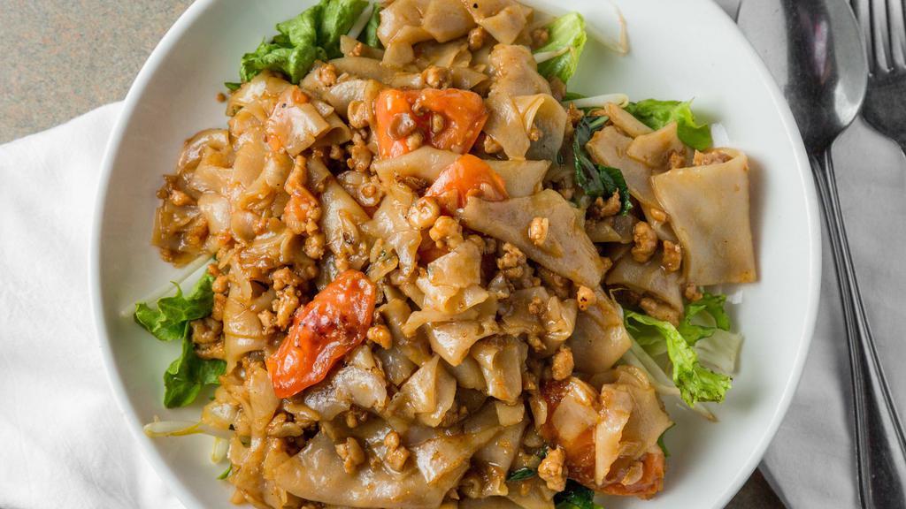 Spicy Drunken Noodles (Pad Kee Mow) · Minced chicken sauteed with wide rice noodles, tomatoes, and Thai basil in a spicy chili garlic sauce, served over a bed of lettuce and bean sprouts.
