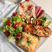 Salmon Filet · Grilled Salmon filet seasoned with herbs and spices & served with humus, rice, salad, and ve...