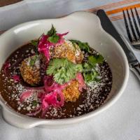 Croquettes · Croquettes filled with adobo braised chicken, served over black bean puree topped withe pick...