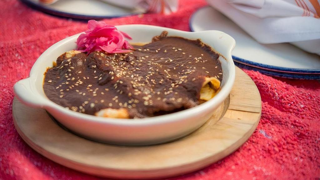 Enchilada De Mole · Cheese stuffed tortillas covered in the slow-cooked mole (contains nuts) and topped with black sesame seeds