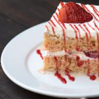 Tres Leches Cake · Huge slice of house made cake topped with whipped cream and fresh strawberries.