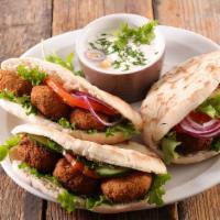 Falafel Sandwich · Your choice of shawarma meat, hummus, tahini sauce, onions, pickles, tomato and cucumber, se...