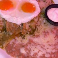Chilaquiles Con Huevo · Tortilla strips sauteed in green or red sauce. Served with refried beans
