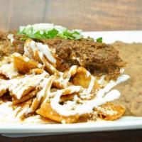 Hangover Chilaquiles · The spicy sauce with sour cream, cotija, cilantro, onion, beans, and birria.
