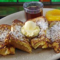French Toast · Four wedges of french toast dusted with powdered sugar and served with butter and syrup