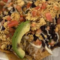 Chilaquiles · Corn tortilla chips, tossed in guajillo chile sauce. Topped with cheese, beans, crema, scram...