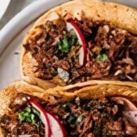 Crispy Grilled Barbacoa Taco · Crispy grilled taco served with juicy barbacoa and grilled onions.