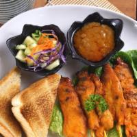 Chicken Satay · grilled marinated chicken breast strips on skewer, served with peanut sauce and cucumber sal...