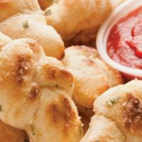 Garlic Knots · Breadsticks all tied up and smothered in buttery garlic sauce, then rolled in parmesan chees...