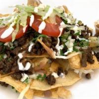 Nachos · Fresh made tortilla chips topped with meat choice, cilantro, onion, lettuce, tomato & cream.