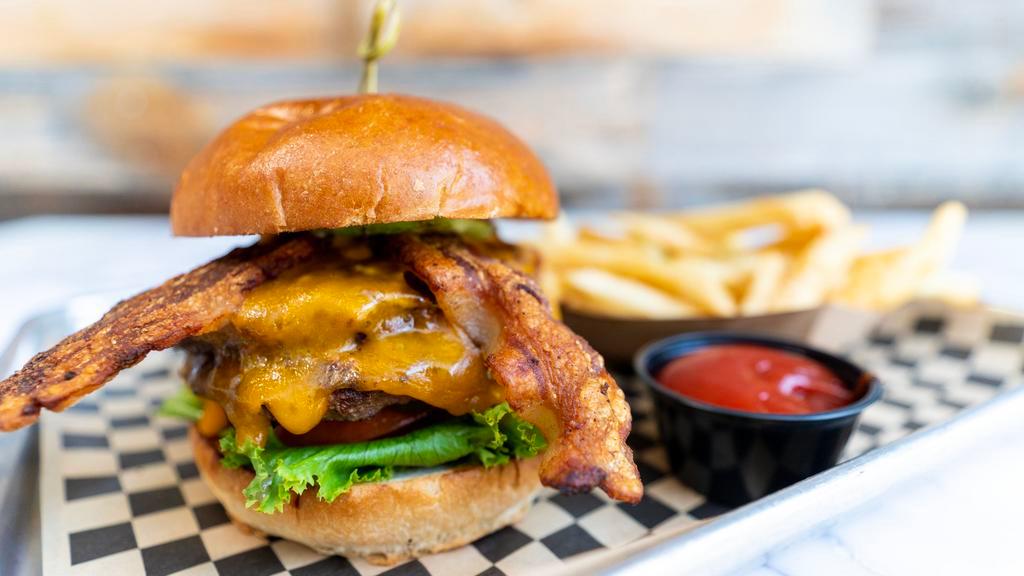 Crawdads Burger · Certified angus beef, red onion, tomato, lettuce, pickles, 1000 island and sharp cheddar cheese, brioche bun served with chips.
