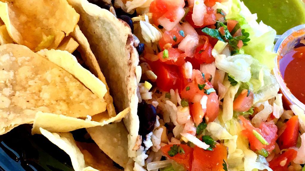Taco Vegetariano · Black beans, rice, and jack cheese topped with shredded lettuce and pico de gallo salsa in a soft shell corn tortilla.