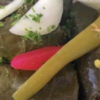 Dolomathes · Grape leaves stuffed with seasoned ground lamb and rice. Served with tzatziki sauce.