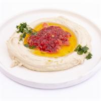 Spicy Hummus · A creamy dip of garbanzo beans, tahini, garlic and topped with shotta. Served with pocket br...