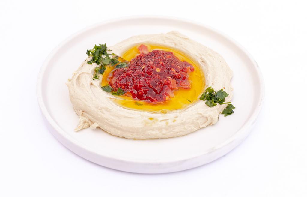 Spicy Hummus · A creamy dip of garbanzo beans, tahini, garlic and topped with shotta. Served with pocket bread.
