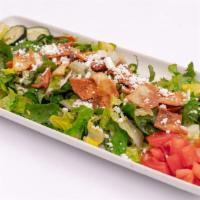 Greek Salad · A refreshing mix of romaine lettuce, tomatoes, cucumbers, pita crisps, spices, with lemon ju...
