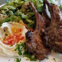 Lamb Chops · 4 grilled chops seasoned to perfection. Served with hummus rice pilaf and salad.