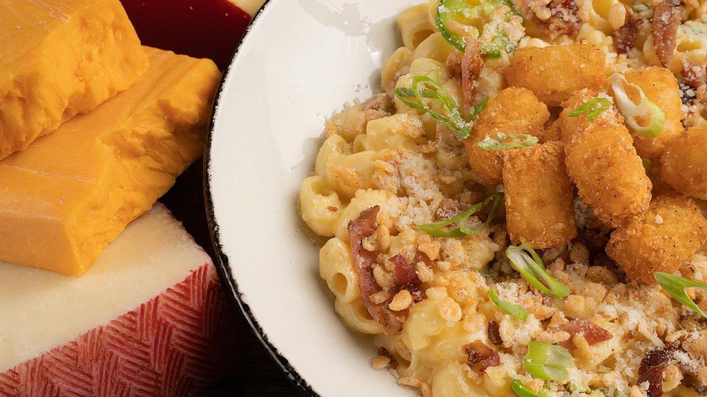 The Popper Tot · mac’s cheese sauce, creamy cheddar & parmesan cheese, spicy jalapeños, crispy bacon, capped with spiced crispies & scallions