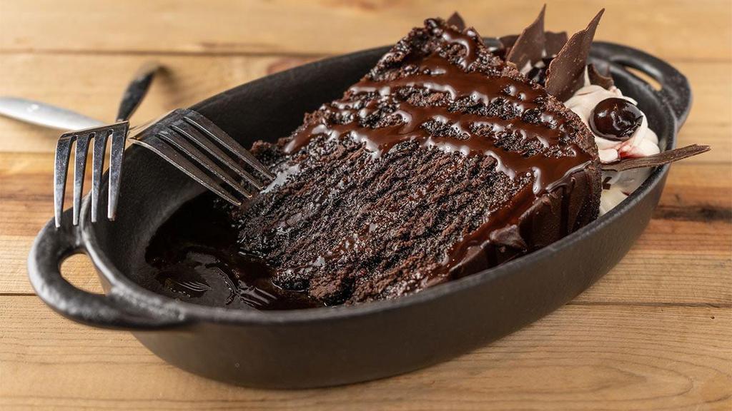 Decadent Chocolate Cake · four cake layers filled with rich milk chocolate. ganache, topped with whipped cream,. chocolate sauce & chocolate shavings