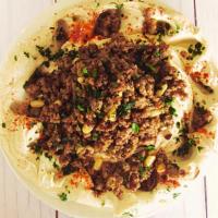 Hummus Awarma · Hummus topped with a rich, preserved beef mixture made with pine nuts, onions and extra virg...