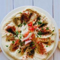 Hummus · A Middle Eastern spread made from chickpeas topped with extra virgin olive oil, paprika, tom...