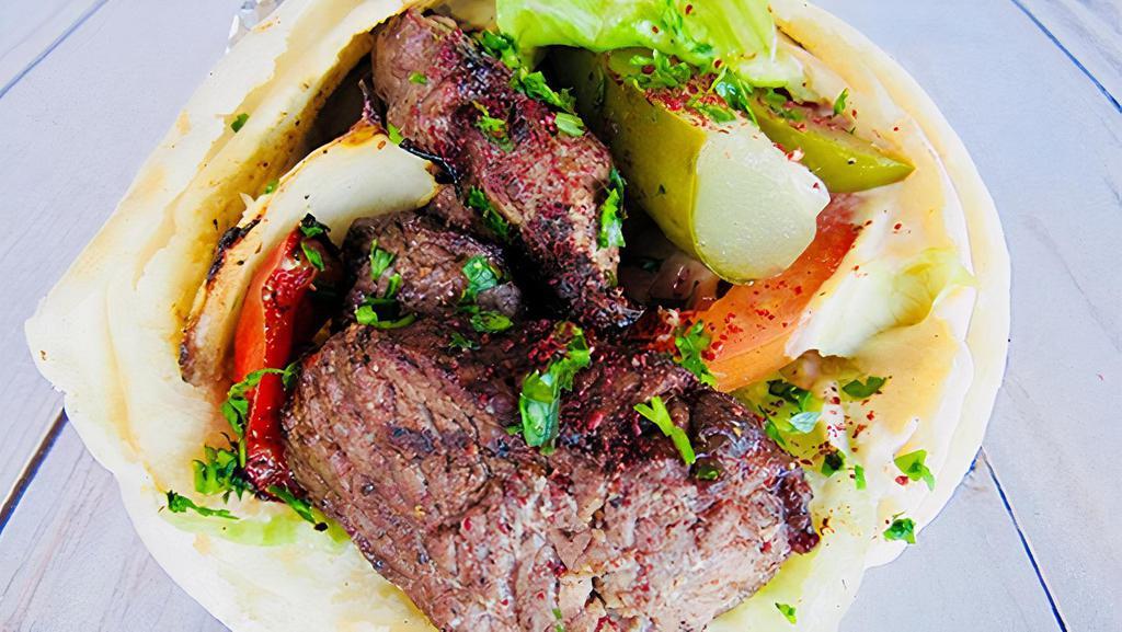 Shish Kebob Sandwich · Tender cubes of lamb, marinated with special seasonings, charbroiled and wrapped in fresh pita bread with hummus, lettuce, tomatoes and pickles.
