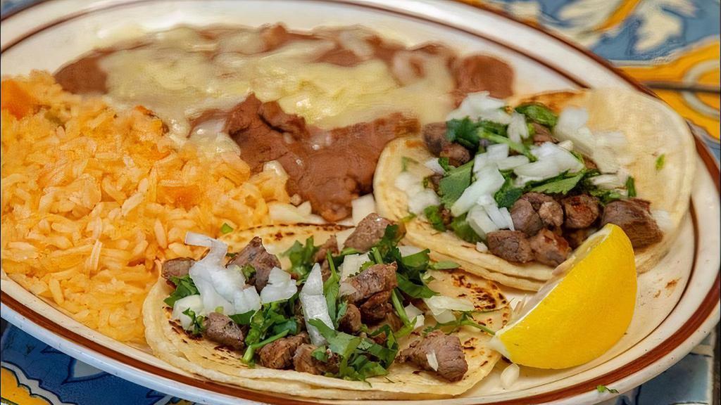 Street Tacos · 3 mini corn tortillas topped with your choice of asada, shredded chicken or shredded beef, topped with onions and cilantro.  Served with rice & beans